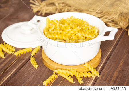 Raw italian torti pasta on brown wood Raw italian torti pasta on brown wood 49383433