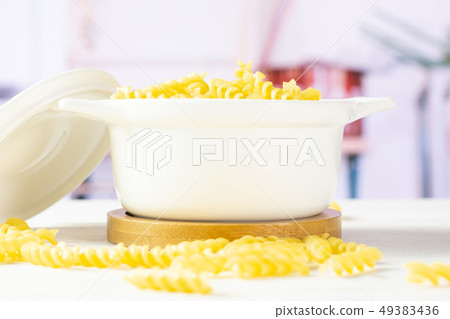 Raw italian torti pasta with kitchen behind Raw italian torti pasta with kitchen behind 49383436