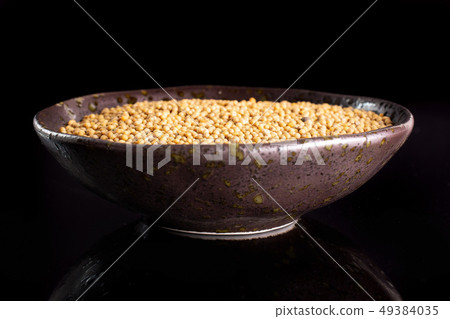 White mustard seeds isolated on black glass White mustard seeds isolated on black glass 49384035