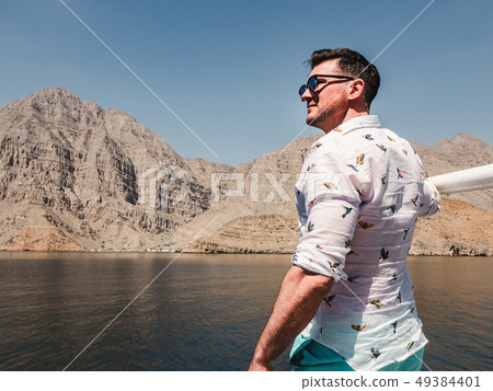 Attractive, fashionable man standing on a boat Attractive, fashionable man standing on a boat 49384401