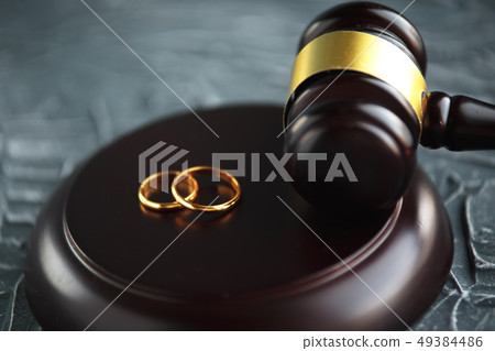Two broken golden wedding rings divorce decree document. Divorce and separation concept 49384486