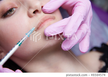 The doctor cosmetologist makes the Rejuvenating facial injections procedure for tightening and 49384574
