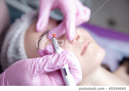 Permanent Makeup For Eyebrows. Microblading brow. Beautician Doing Eyebrow Tattooing For Female Face Permanent Makeup For Eyebrows. Microblading brow. Beautician Doing Eyebrow Tattooing For Female Face 49384640