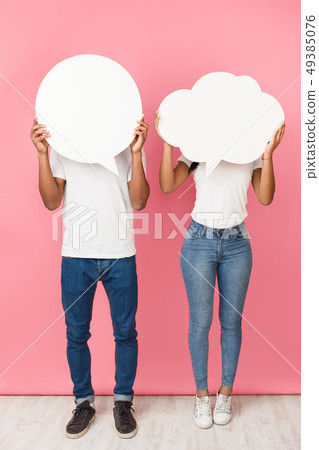 Speech bubbles. Couple holding empty boards, closing their faces Speech bubbles. Couple holding empty boards, closing their faces 49385076