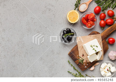 Block of feta cheese and vegetables on concrete background Block of feta cheese and vegetables on concrete background 49385248