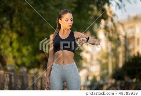 Young woman athlete with heart rate watch or fitness bracelet Young woman athlete with heart rate watch or fitness bracelet 49385919