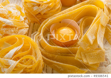 Raw yellow italian pasta pappardelle, fettuccine Raw yellow italian pasta pappardelle, fettuccine 49386541