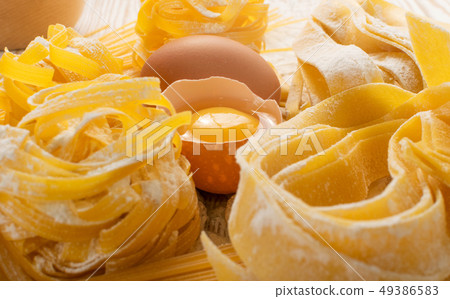Raw yellow italian pasta pappardelle, fettuccine Raw yellow italian pasta pappardelle, fettuccine 49386583