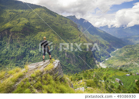Man standing on hill top in Himalayas 49386930