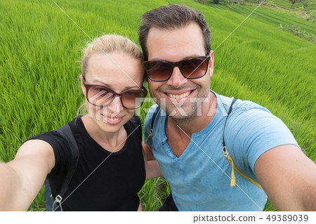 Beautiful love couple having fun taking selfie at beautiful Jatiluwih rice terrace plantations on 49389039