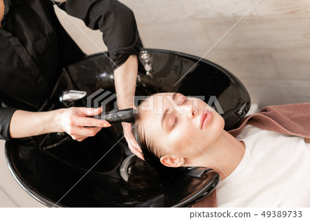 beautiful girl washes her hair before a haircut in a beauty salon. hair washing at a hairdressing 49389733