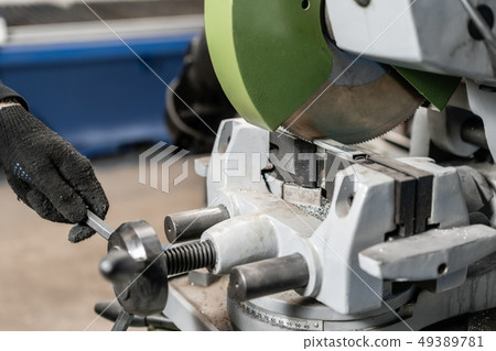worker cuts a piece of material with a circular saw machine. Industrial engineer working on cutting 49389781