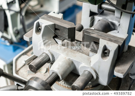 vise to secure the workpiece. Circular saw machine. Cutting a metal and steel with with sharp 49389782