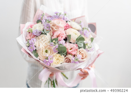 beautiful fresh cut bouquet of mixed flowers in woman hand. the work of the florist at a flower shop 49390224