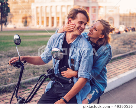 Lovely young couple driving electric bike during summer 49390536