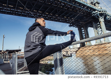 Athlete man stretching up before running workout 49391713