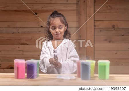 a long hair boy playing colors in wooden room a long hair boy playing colors in wooden room 49393207