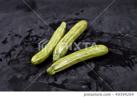 Fresh green wet zucchini. 49394264