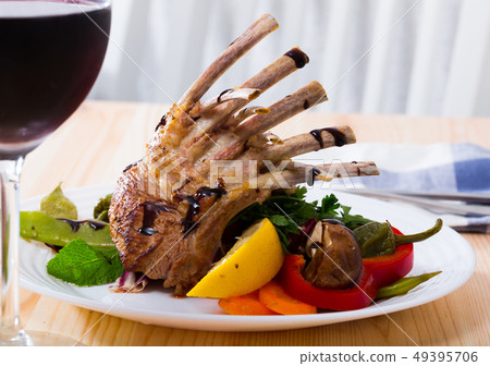 Roasted rack of mutton with vegetables and red wine 49395706