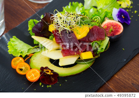 Close up of tasty salad of raw tuna, avocado, mango and greens Close up of tasty salad of raw tuna, avocado, mango and greens 49395872
