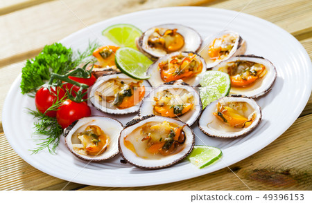 Deliciously baked dog with lemon, cherry tomatoes and greens at plate 49396153