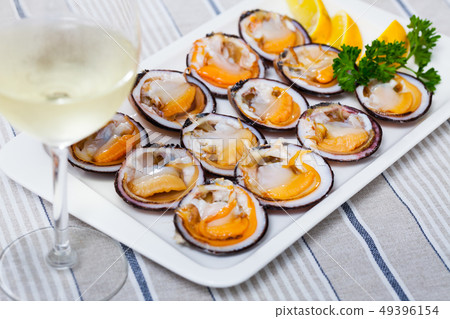 Raw dog cockles with lemon, greens and wine 49396154