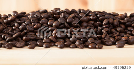 Coffee beans on light wood surface Coffee beans on light wood surface 49396239