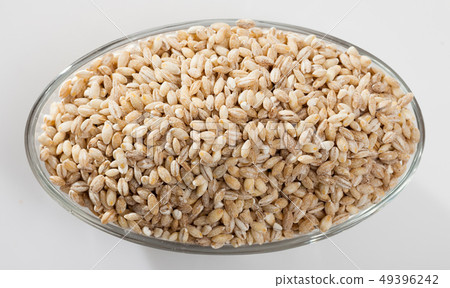 Barley groats in glass bowl on white surface , nobody Barley groats in glass bowl on white surface , nobody 49396242