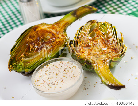 Roasted halved artichoke with kosher salt 49396443