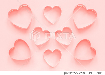 Pink cutters cookies in heart shape on pastel pink Pink cutters cookies in heart shape on pastel pink 49396905
