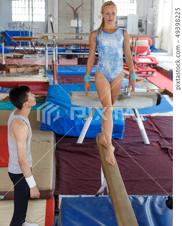 Woman doing exercises on balance beam Woman doing exercises on balance beam 49398225