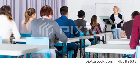 Students working with professor in auditorium 49398635