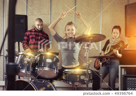 Music band with glad girl drummer rehearsing Music band with glad girl drummer rehearsing 49398764