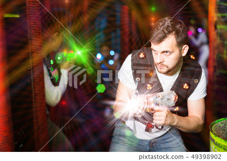 Guy in colored beams during laser tag game 49398902