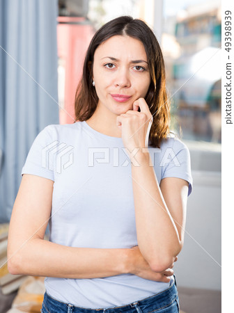 Sad girl is standing in home interior, thinking about troubles Sad girl is standing in home interior, thinking about troubles 49398939