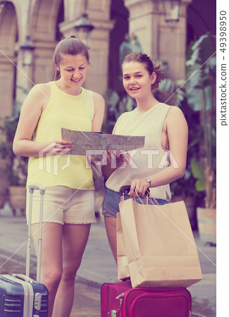 women friends having map and searching tourist route in the city 49398950