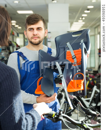 Adult seller demonstrating bicycle sit for child 49398951