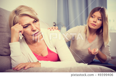 daughter comforts a sad mother 49399406