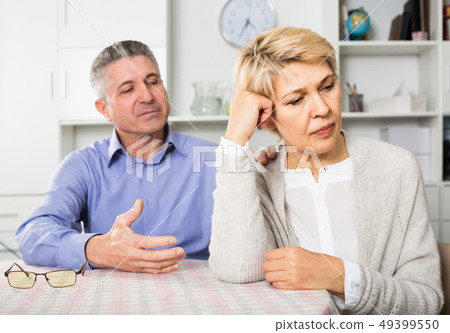 Husband and wife arguing with each other and try to resolve family conflict at table Husband and wife arguing with each other and try to resolve family conflict at table 49399550