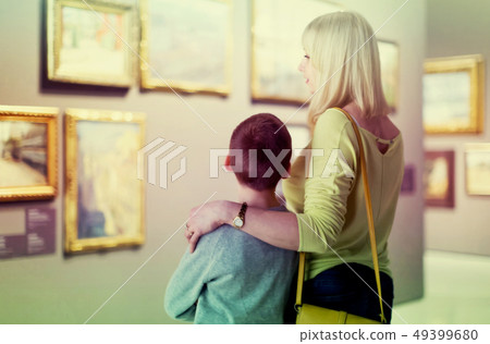 Mother and son looking at paintings in halls of museum Mother and son looking at paintings in halls of museum 49399680