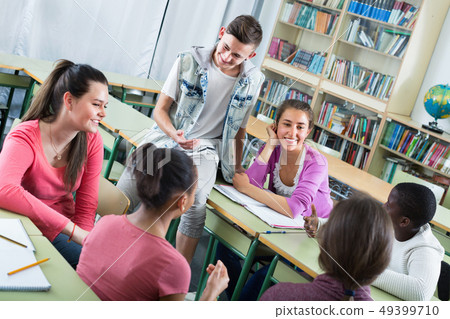 Girls and boys relaxing together between the classes Girls and boys relaxing together between the classes 49399710