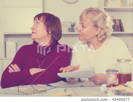 Elderly woman with papers calming female 49400077