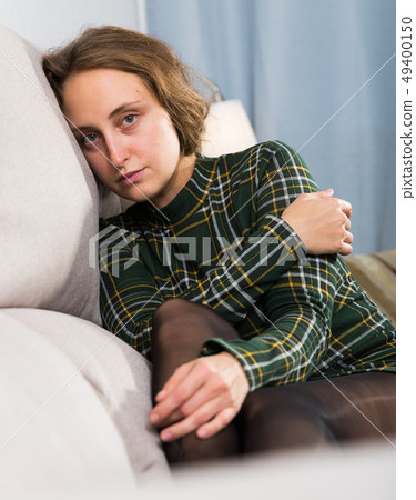 Portrait of sorrowful woman sitting at home 49400150