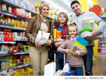 Parents with two kids holding purchases in store Parents with two kids holding purchases in store 49400156