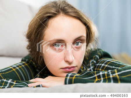 Portrait of sorrowful woman sitting at home Portrait of sorrowful woman sitting at home 49400163