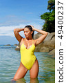 Beautiful girl posing on the beach in the hot sun 49400237