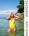 Beautiful girl posing on the beach in the hot sun 49400243