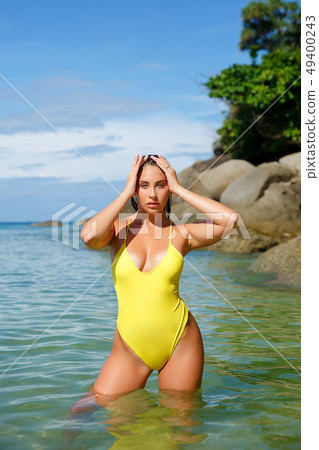 Beautiful girl posing on the beach in the hot sun Beautiful girl posing on the beach in the hot sun 49400243