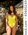 Beautiful girl posing on the beach in the hot sun 49400249