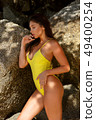 Beautiful girl posing on the beach in the hot sun 49400254